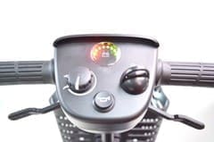 Close-up of a scooter dashboard with control knobs and a digital display.
