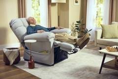 A man reclining in an electric recliner chair.