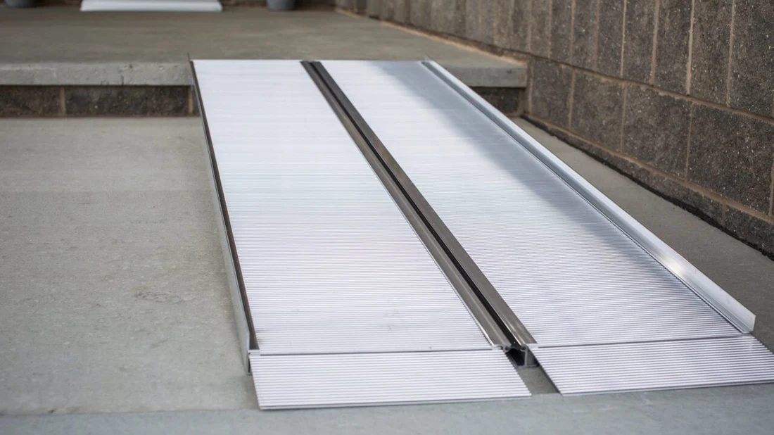 Metal sheets stacked and aligned outdoors near a building.