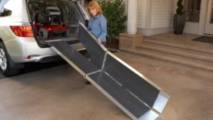 Person setting up a foldable ramp from a car trunk.