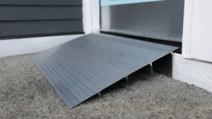 Close-up of a black plastic ramp on the ground near a door.