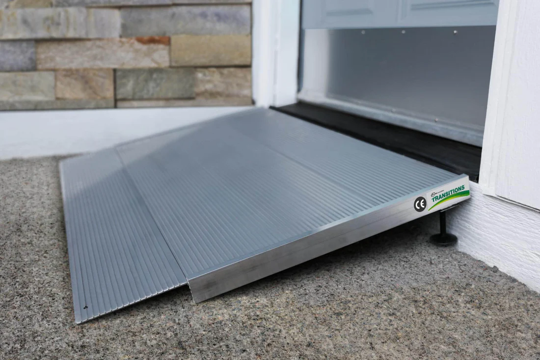 Aluminum wheelchair ramp installed at a door threshold.