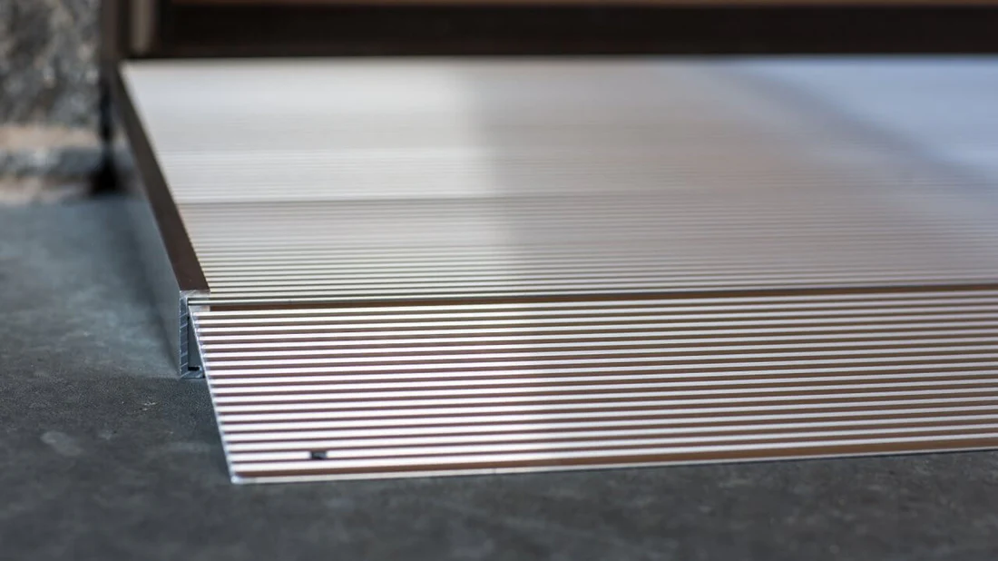 Stacked corrugated metal sheets on a concrete floor.