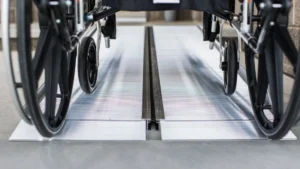 Close-up of wheelchair wheels on a metal track.