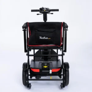 A modern, compact black mobility scooter with red accents on a white background.
