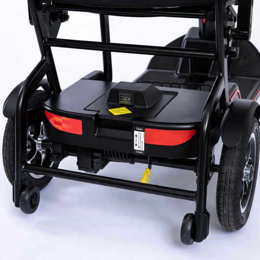 Close-up of the rear section of a wheelchair with footrests and brakes.