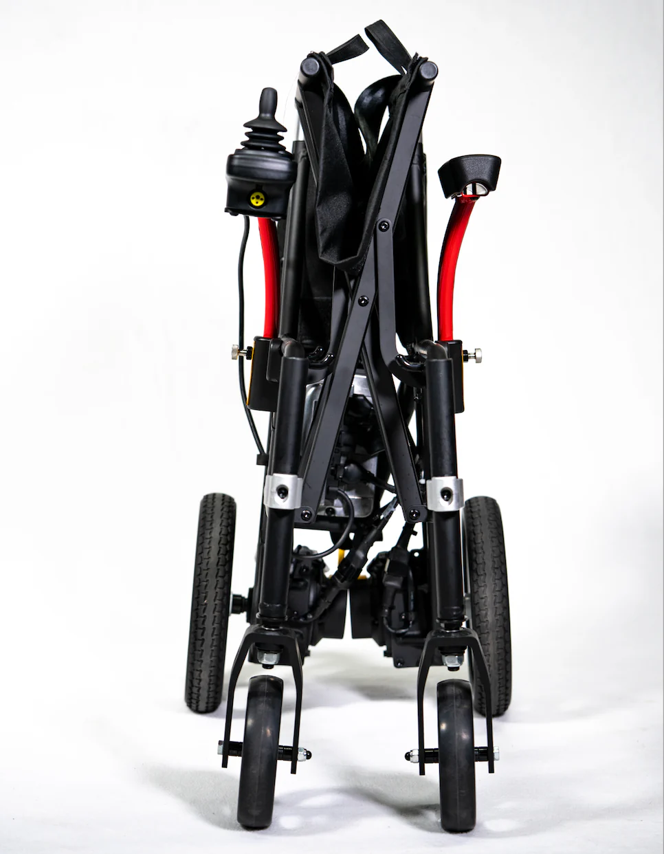 Rear view of a folded black stroller with red accents and wheels.