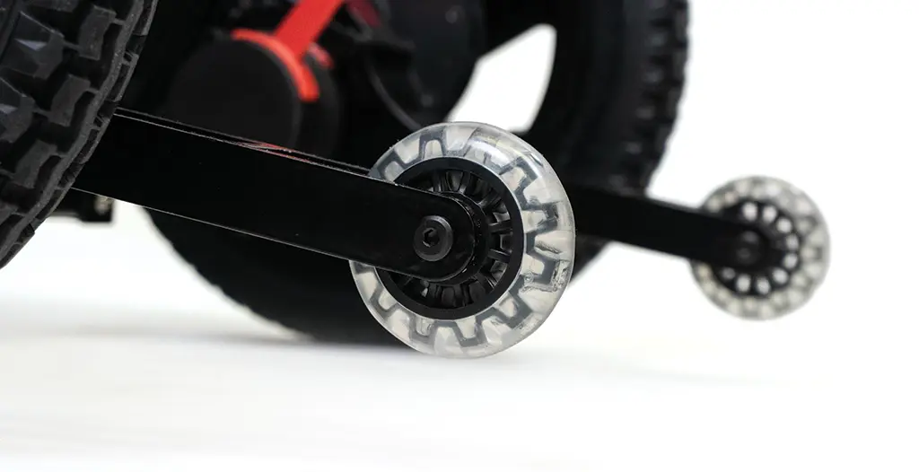 Close-up of a transparent stabilizer wheel on a child's bicycle.