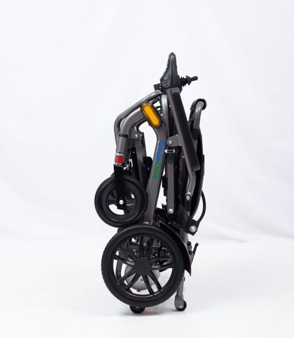 Folded black stroller with large wheels against white background.