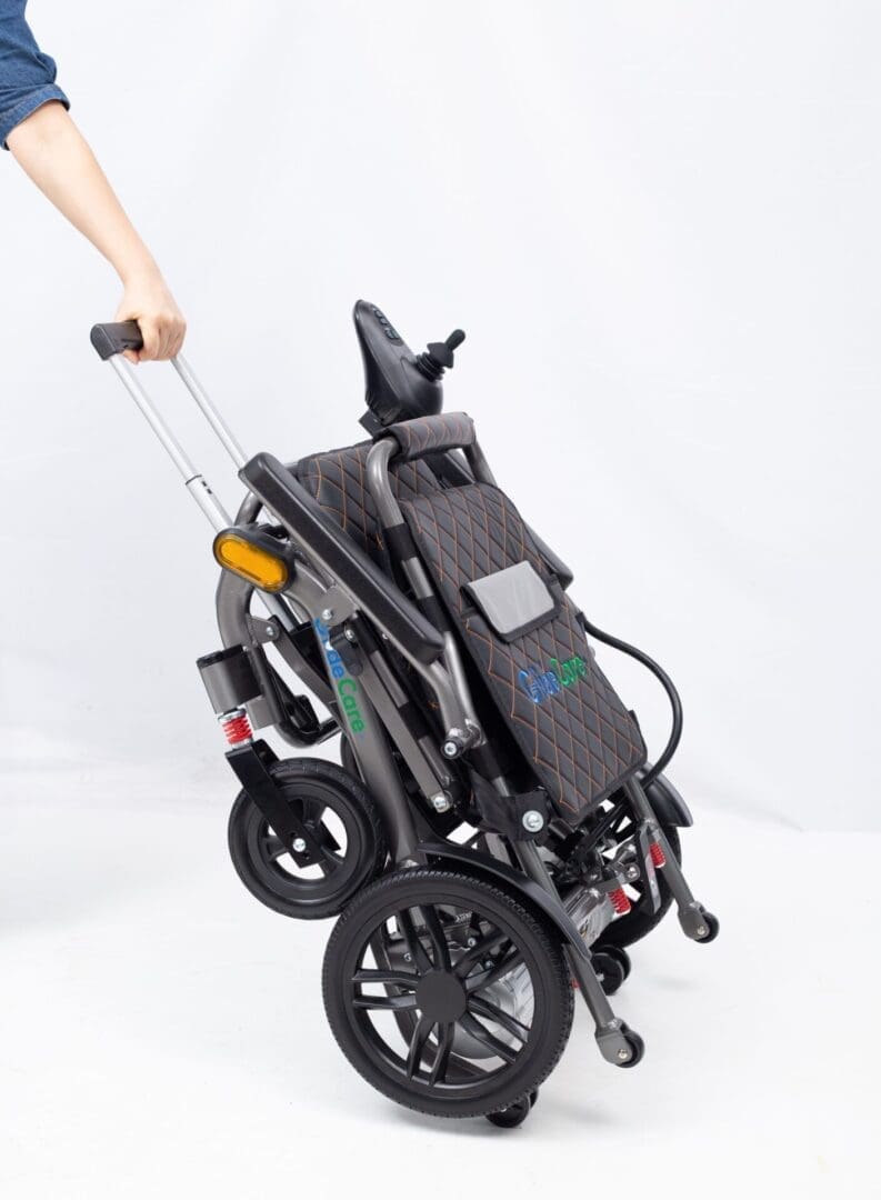 Folded black stroller with large wheels and adjustable handle.