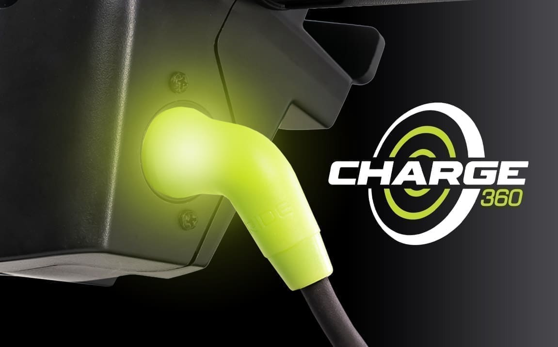 Close-up of a glowing green electric vehicle charging plug.