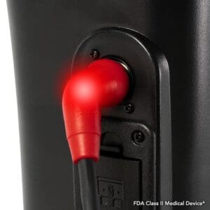 Close-up of a red medical device connector plugged into a black machine port.