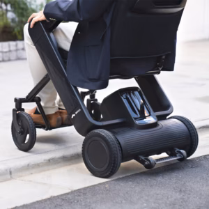 A person sitting on a modern electric mobility scooter outdoors.