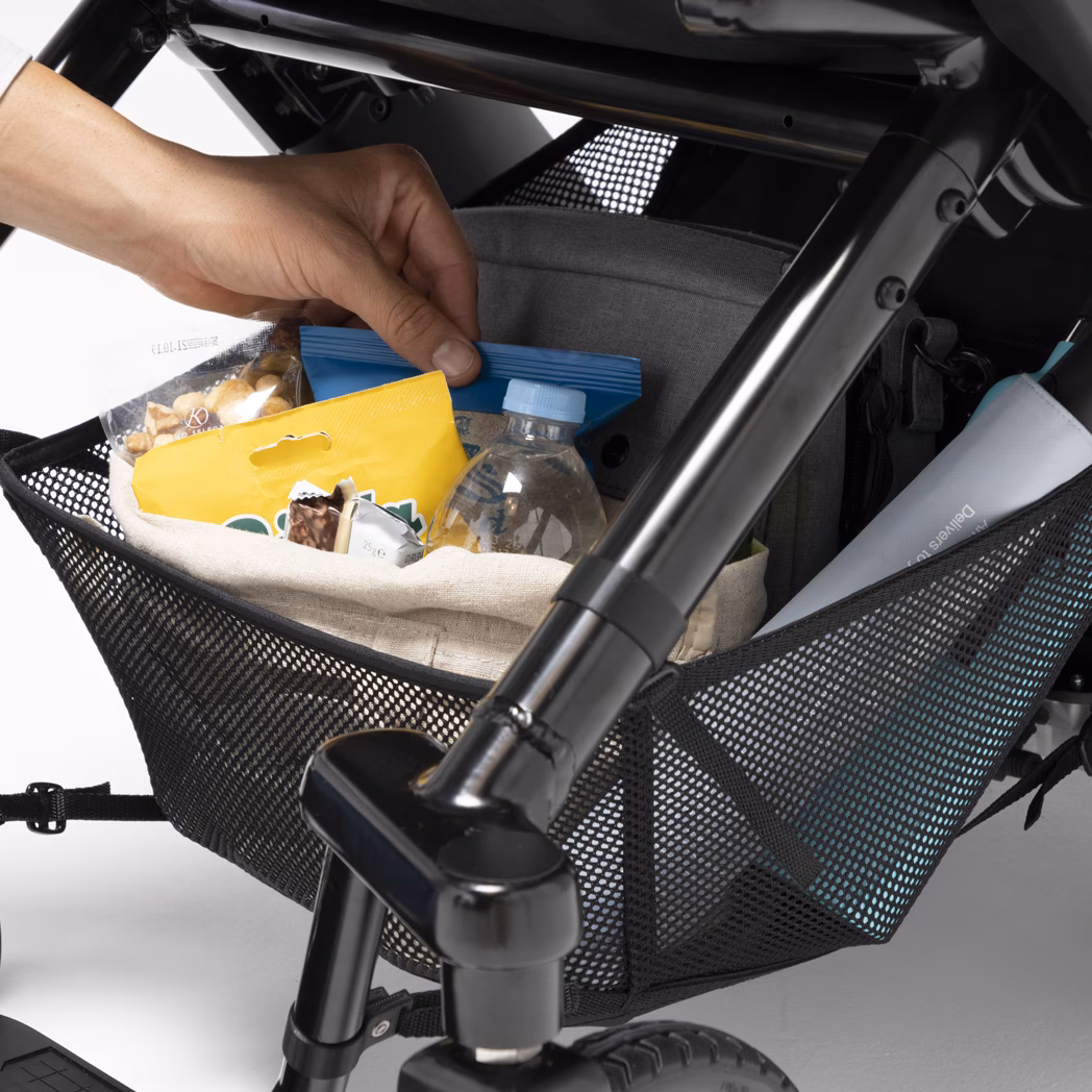 Storage basket under stroller holding baby supplies.