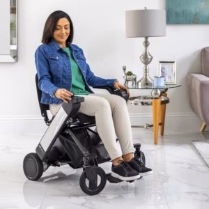 Woman sitting on a compact electric mobility scooter indoors.