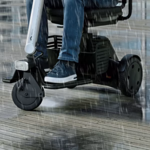 Person riding a motorized scooter on a rainy day.