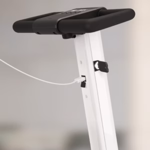 Close-up of a white treadmill handle with a charging cable plugged in.