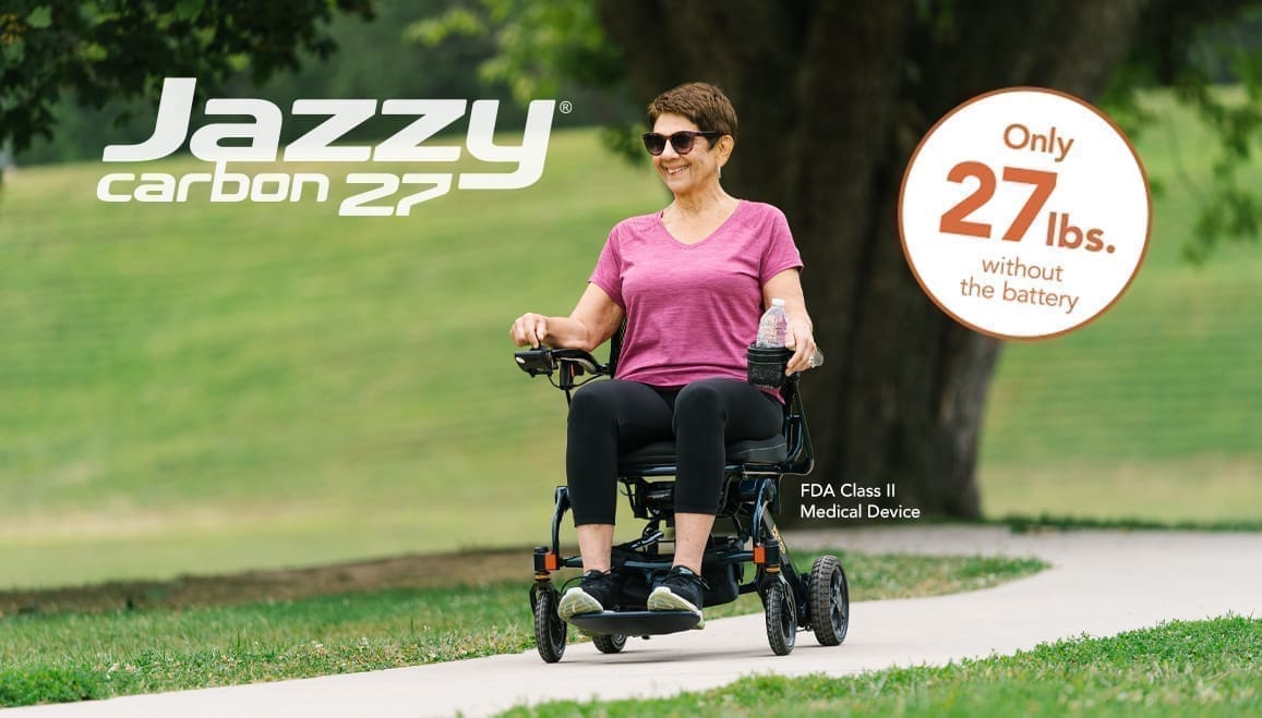 Woman riding a compact, foldable electric wheelchair outdoors.